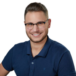 Uśmiechnięty mężczyzna w okularach, ekspert stomatologii z Katowic.