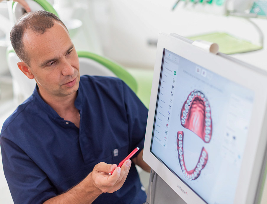 Dentysta badający obraz na ekranie komputera w klinice dentystycznej.