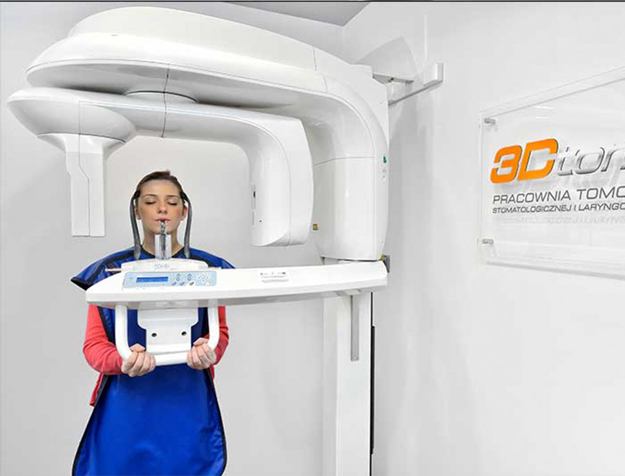Kobieta stoi przed aparatem rentgenowskim w klinice implantologicznej w Katowicach.