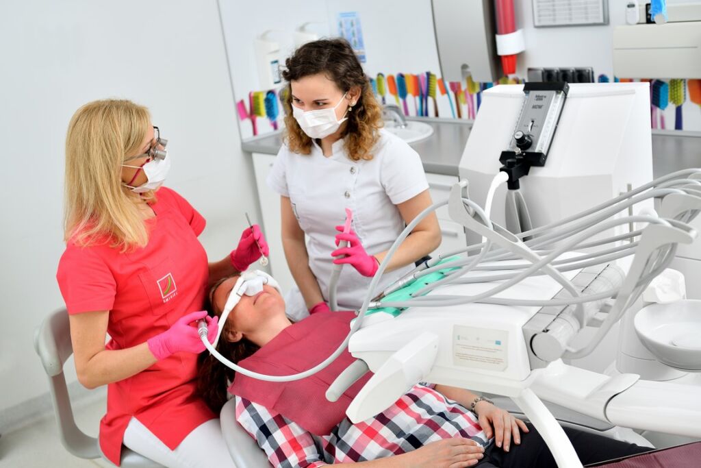 Kobieta jest badana przez dentystę pod kątem bezbolesnej stomatologii w gabinecie dentystycznym.